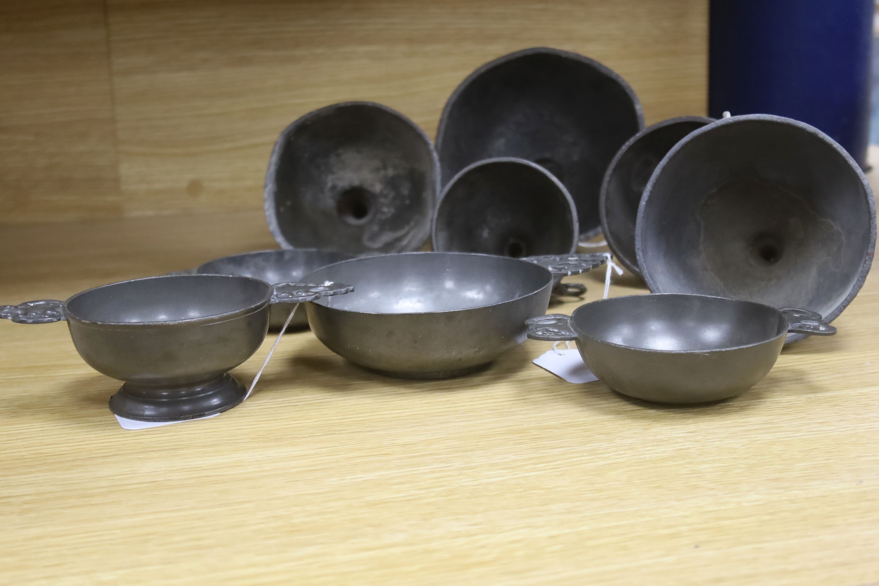 Nine items of 18th and 19th century pewter, including three quaich, a blood letting type bowl and five wine funnels, widest 15cm